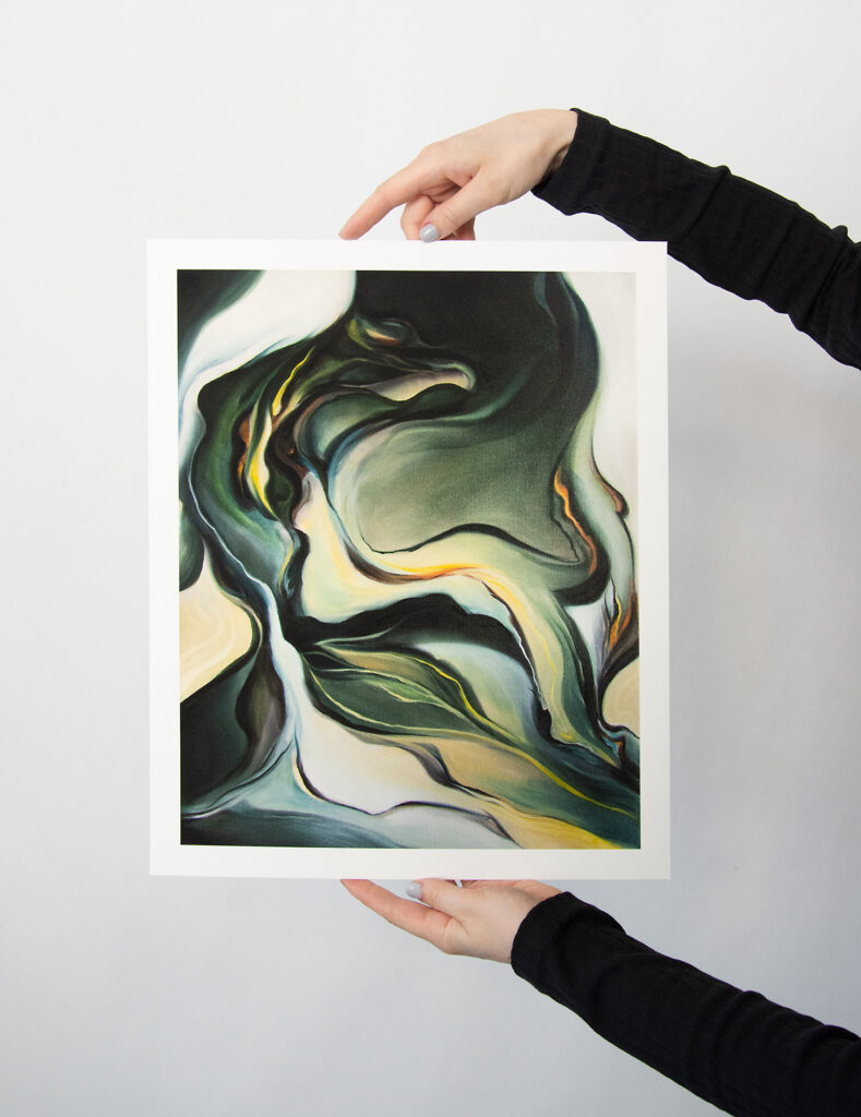 A person holding a small format fine art print titled 'Marble' by Evelina Klanikova, featuring an abstract representation of marble, positioned in front of a white wall.